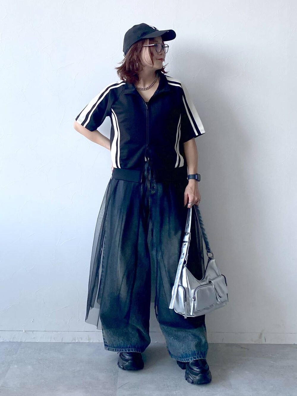 ブラック系のスニーカー、シルバー系のショルダーバッグ、ブルー系のデニムパンツを着用したレディースの夏コーディネートの8枚目の写真