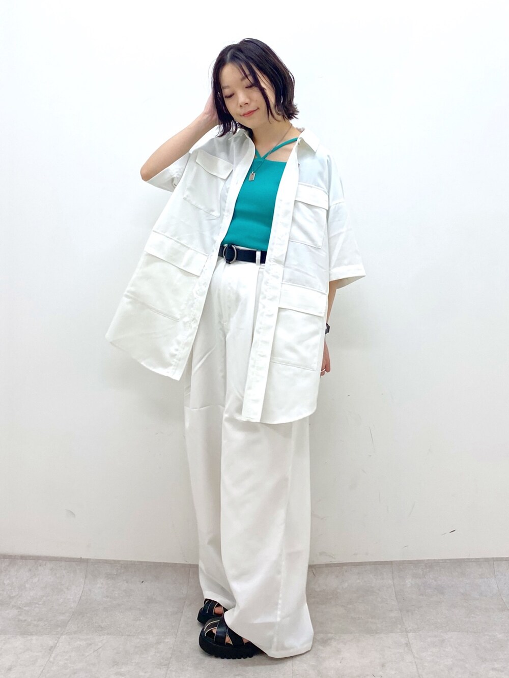 ホワイト系のパンツ、ブラック系のサンダル、ホワイト系のトップスを着用したレディースの春コーディネートの3枚目の写真