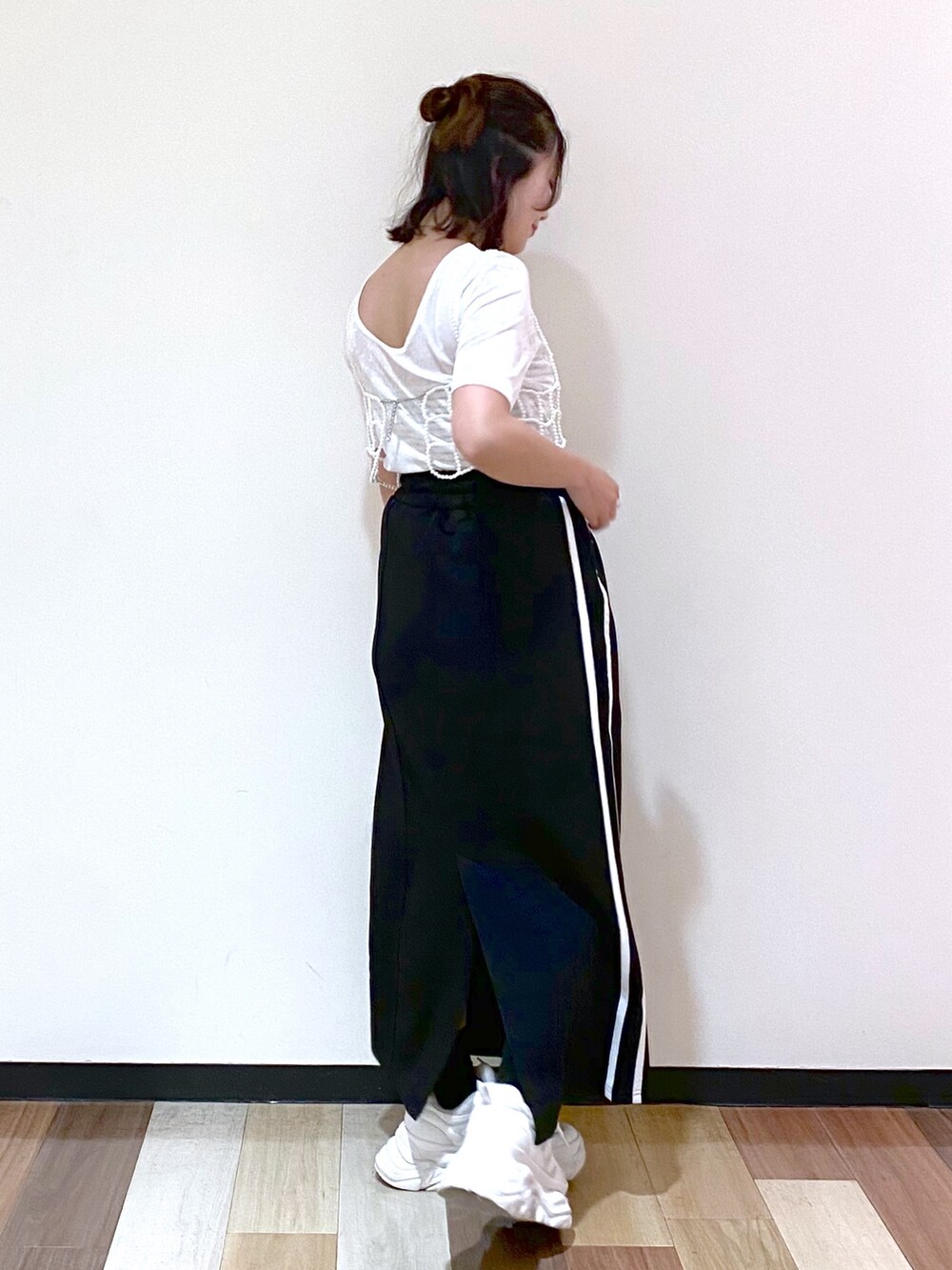 ブラック系のスカート、シルバー系のショルダーバッグ、ホワイト系のスニーカーを着用したレディースの夏コーディネートの7枚目の写真