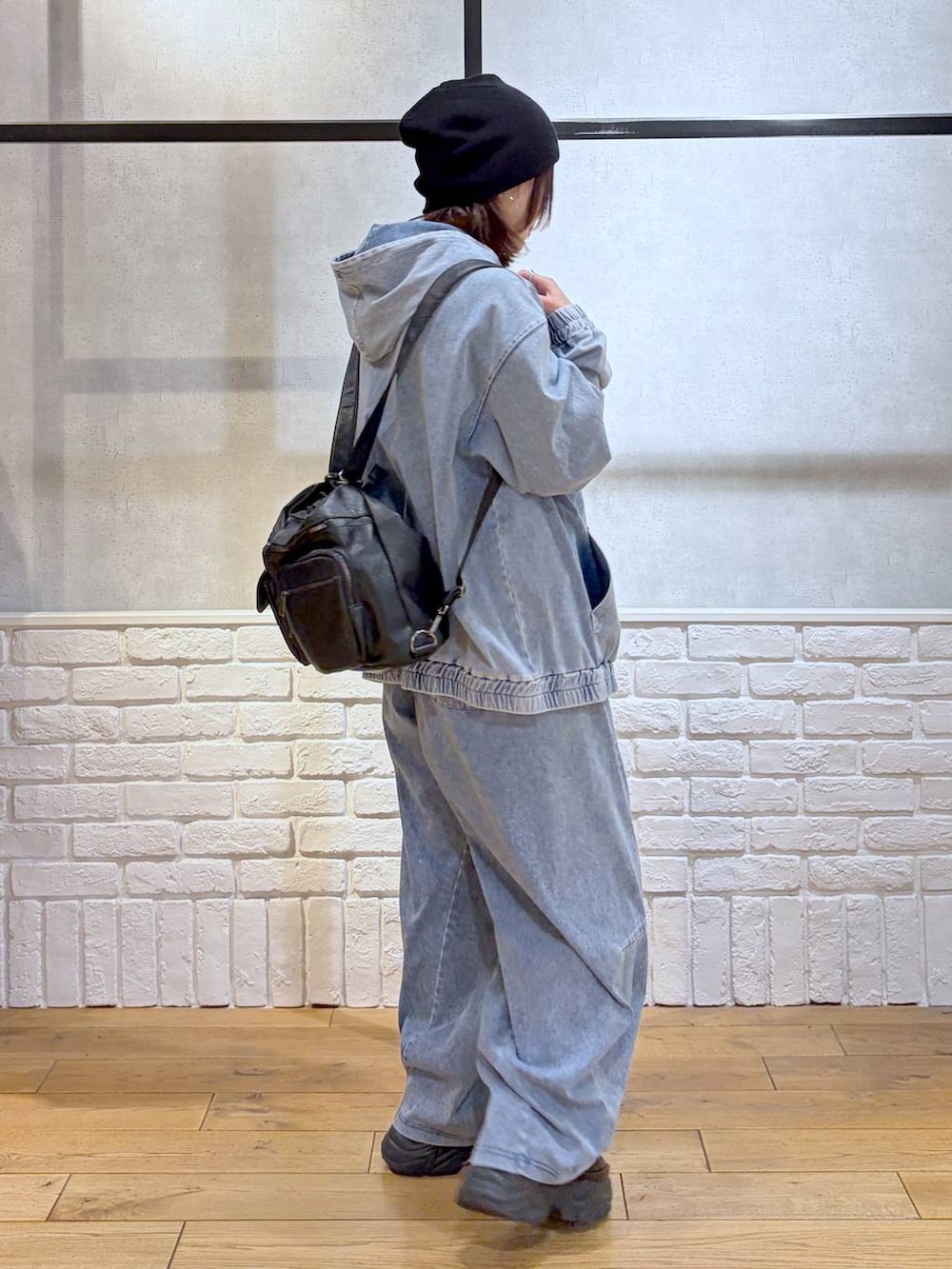 ブラック系のスニーカー、ブラック系のショルダーバッグ、ブルー系のパーカーを着用したレディースの春コーディネートの7枚目の写真