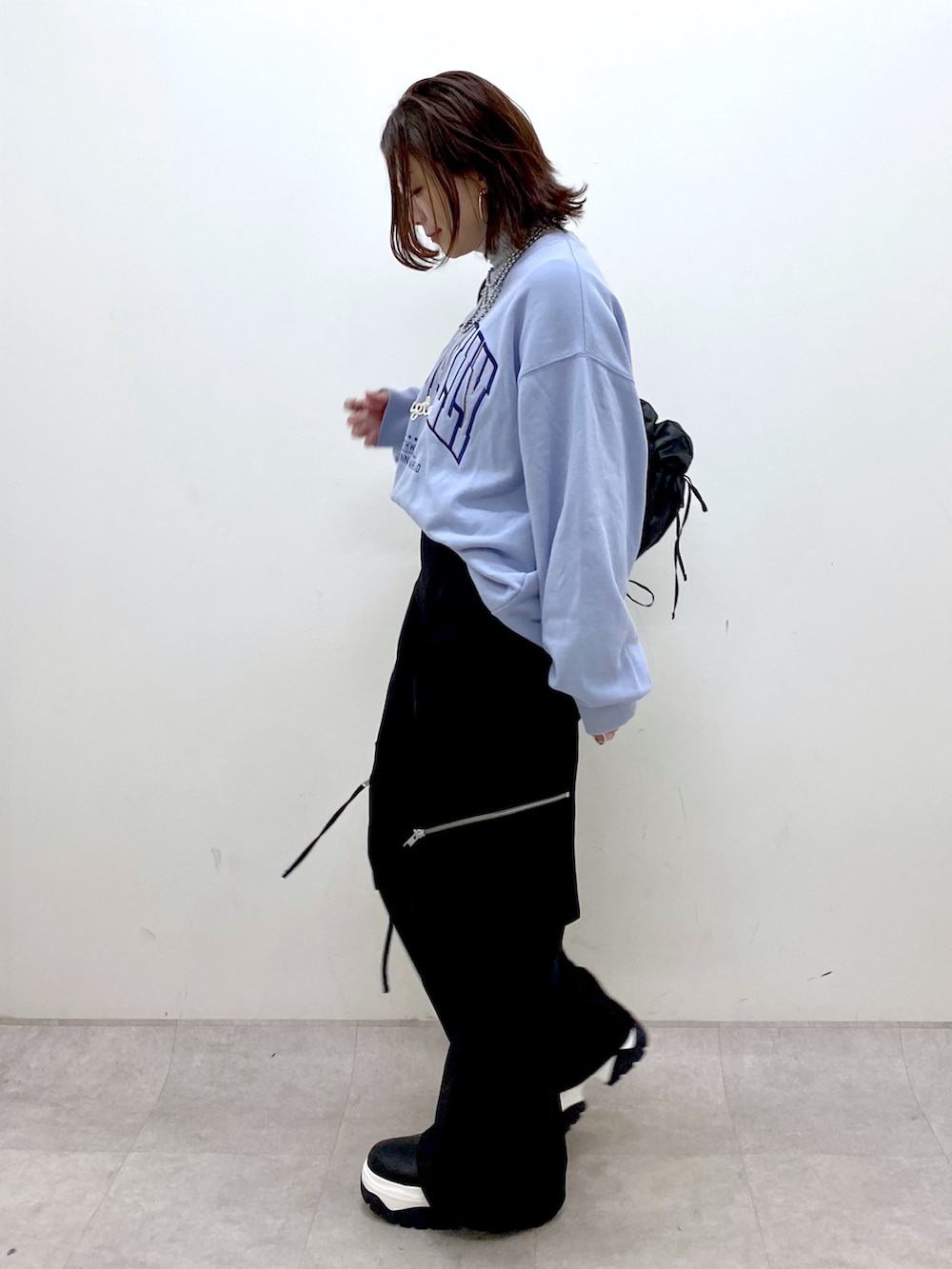 ブルー系のスウェット、ブラック系のカーゴパンツ、ブラック系のブーツを着用したレディースの冬コーディネートの7枚目の写真