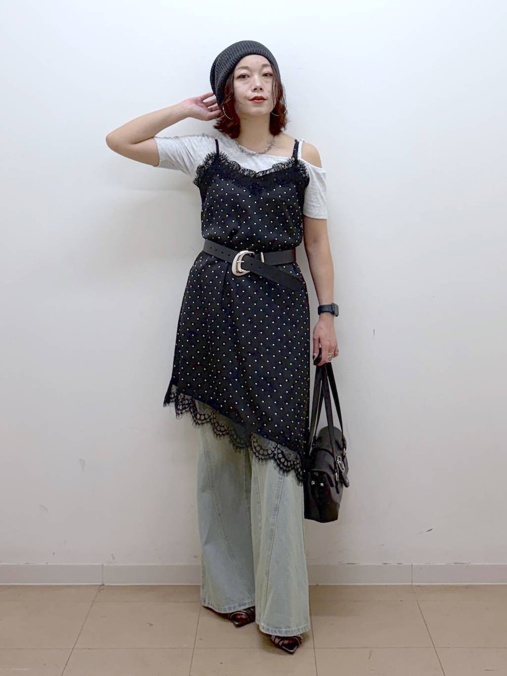 ブラック系のチュニック、ブルー系のデニムパンツ、その他のサンダルを着用したレディースの夏コーディネートの4枚目の写真