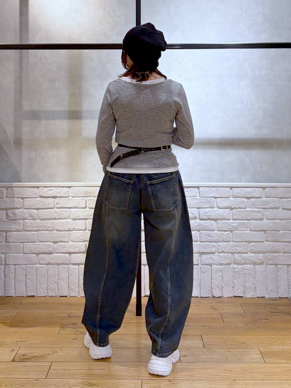 ホワイト系のスニーカー、ブラック系のボディバッグ/ウエストポーチ、ブルー系のデニムパンツを着用したレディースの春コーディネートの6枚目の写真