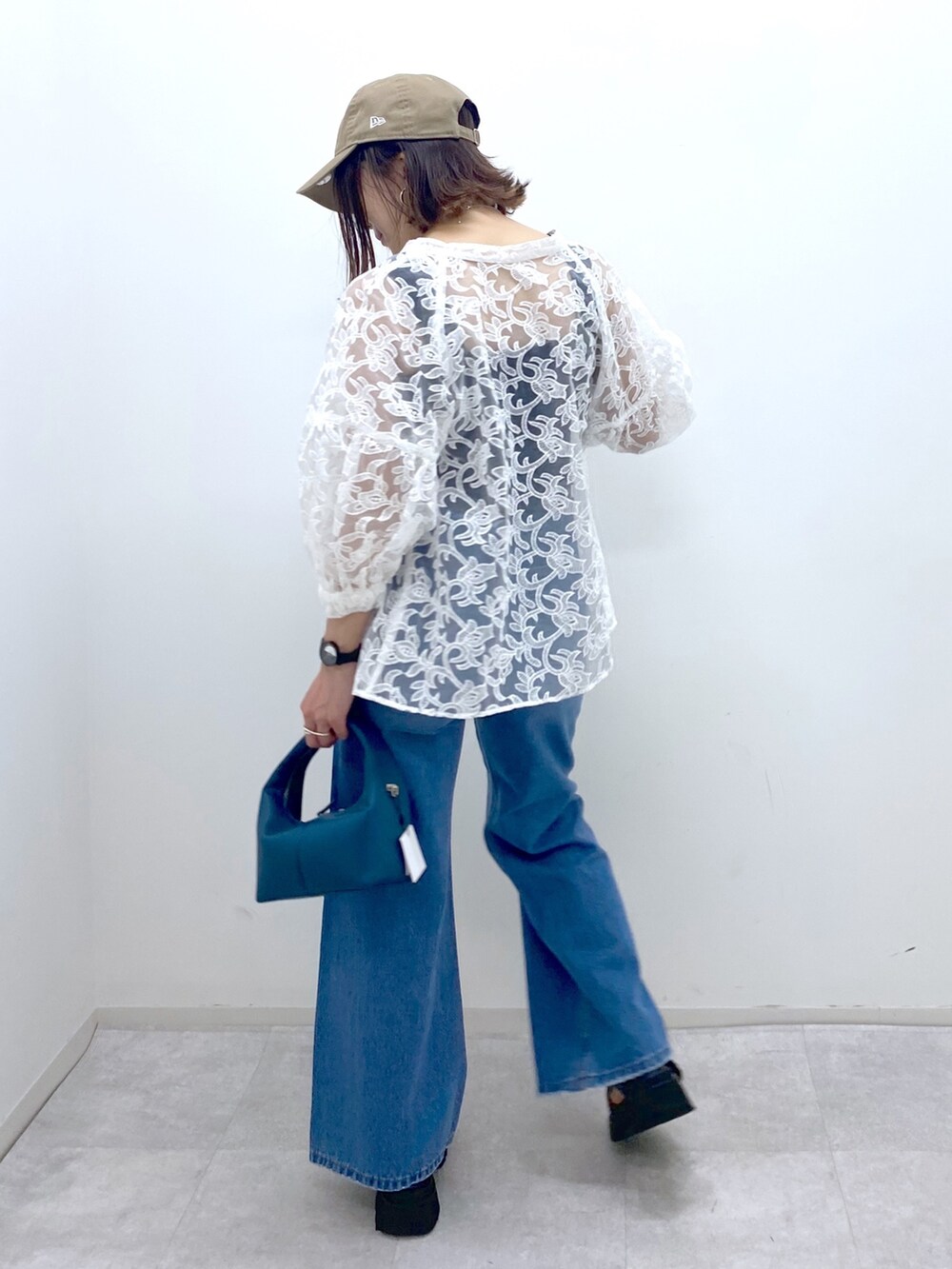 ブルー系のパンツ、ブラック系のサンダル、ブルー系のショルダーバッグを着用したレディースの夏コーディネートの4枚目の写真