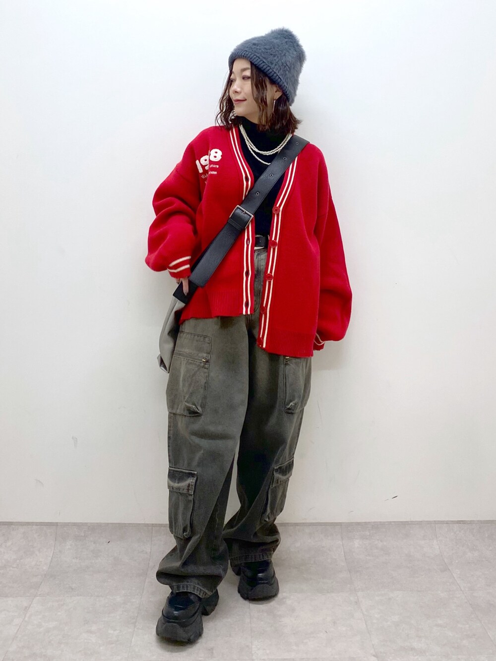 ブラック系のデニムパンツ、ブラック系のブーツ、シルバー系のトートバッグを着用したレディースの秋コーディネートの4枚目の写真