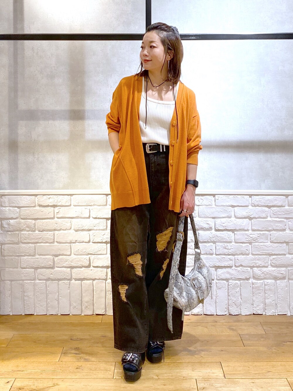 ホワイト系のタンクトップ、オレンジ系のカーディガン/ボレロ、ブラック系のデニムパンツを着用したレディースの春コーディネートの9枚目の写真