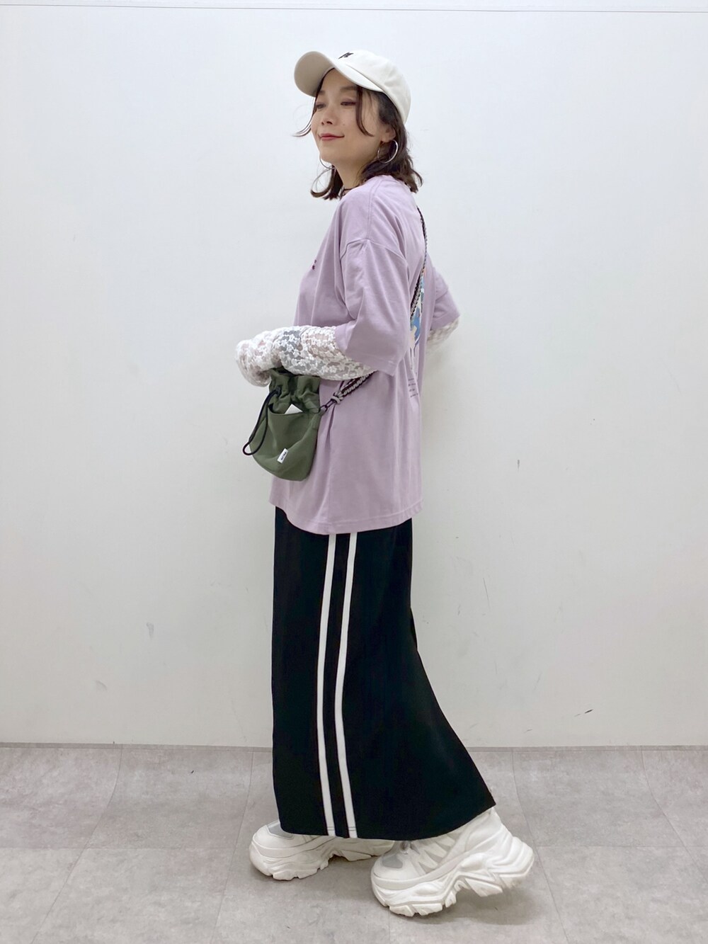 ブラック系のスカート、ホワイト系のスニーカー、ホワイト系のTシャツ/カットソーを着用したレディースの夏コーディネートの5枚目の写真