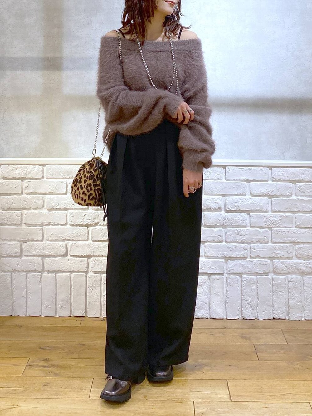 その他のブーツ、ブラック系のスラックス、ブラウン系のニット/セーターを着用したレディースの秋コーディネートの3枚目の写真