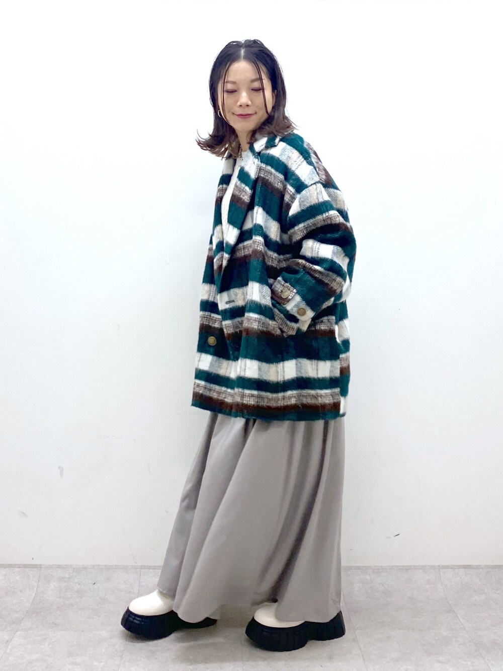 グリーン系のその他アウター、ホワイト系のニット/セーター、ホワイト系のワンピースを着用したレディースの冬コーディネートの3枚目の写真