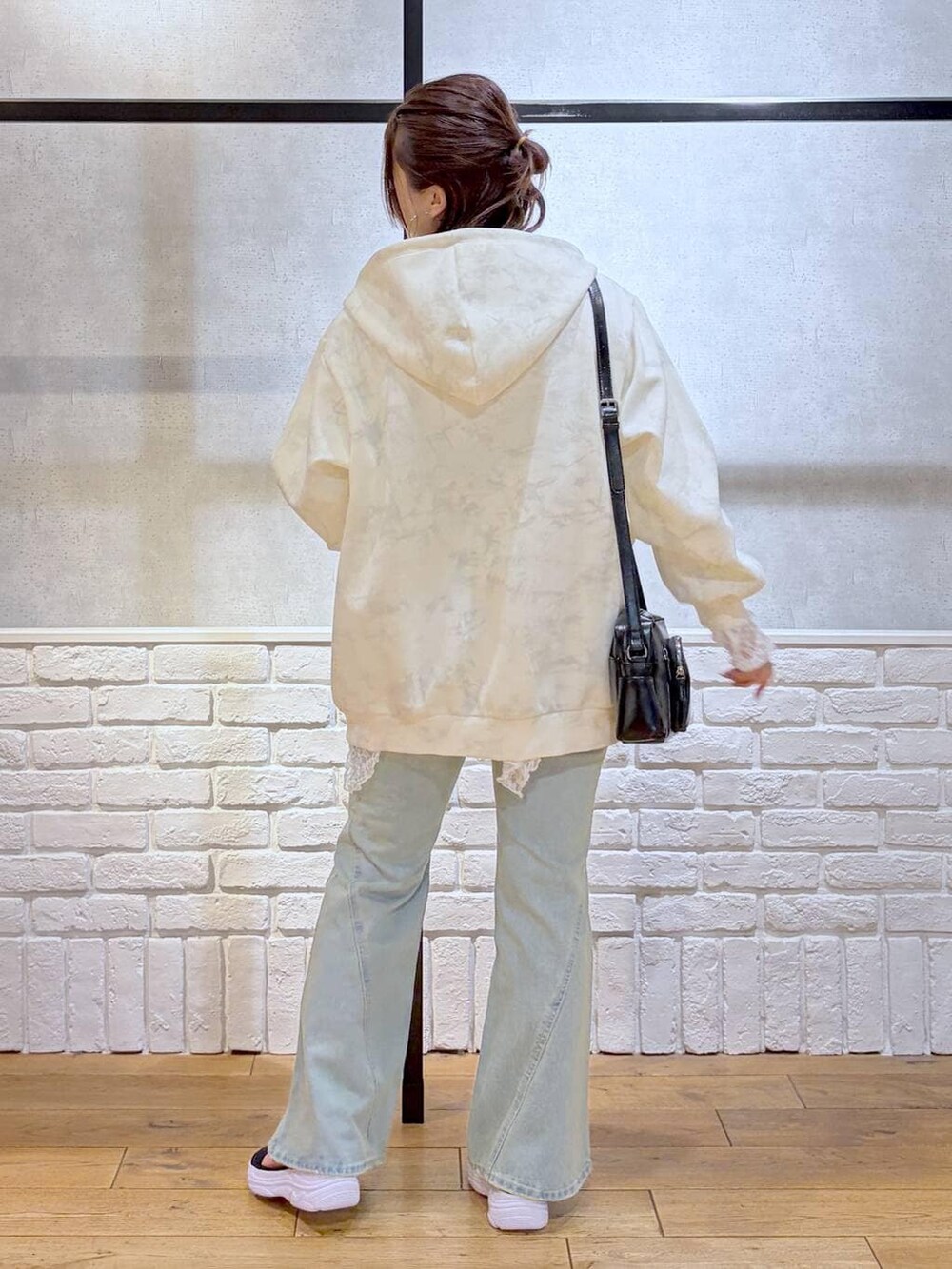 ブルー系のデニムパンツ、ホワイト系のパーカー、ホワイト系のチュニックを着用したレディースの春コーディネートの7枚目の写真
