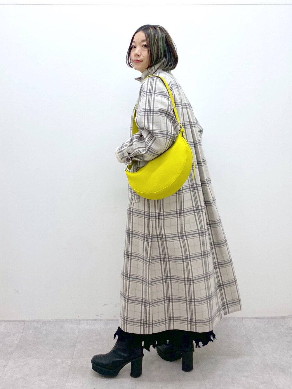 ホワイト系のジャケット/アウター、ブラック系のブーツ、ブラック系のスカートを着用したレディースの冬コーディネートの2枚目の写真