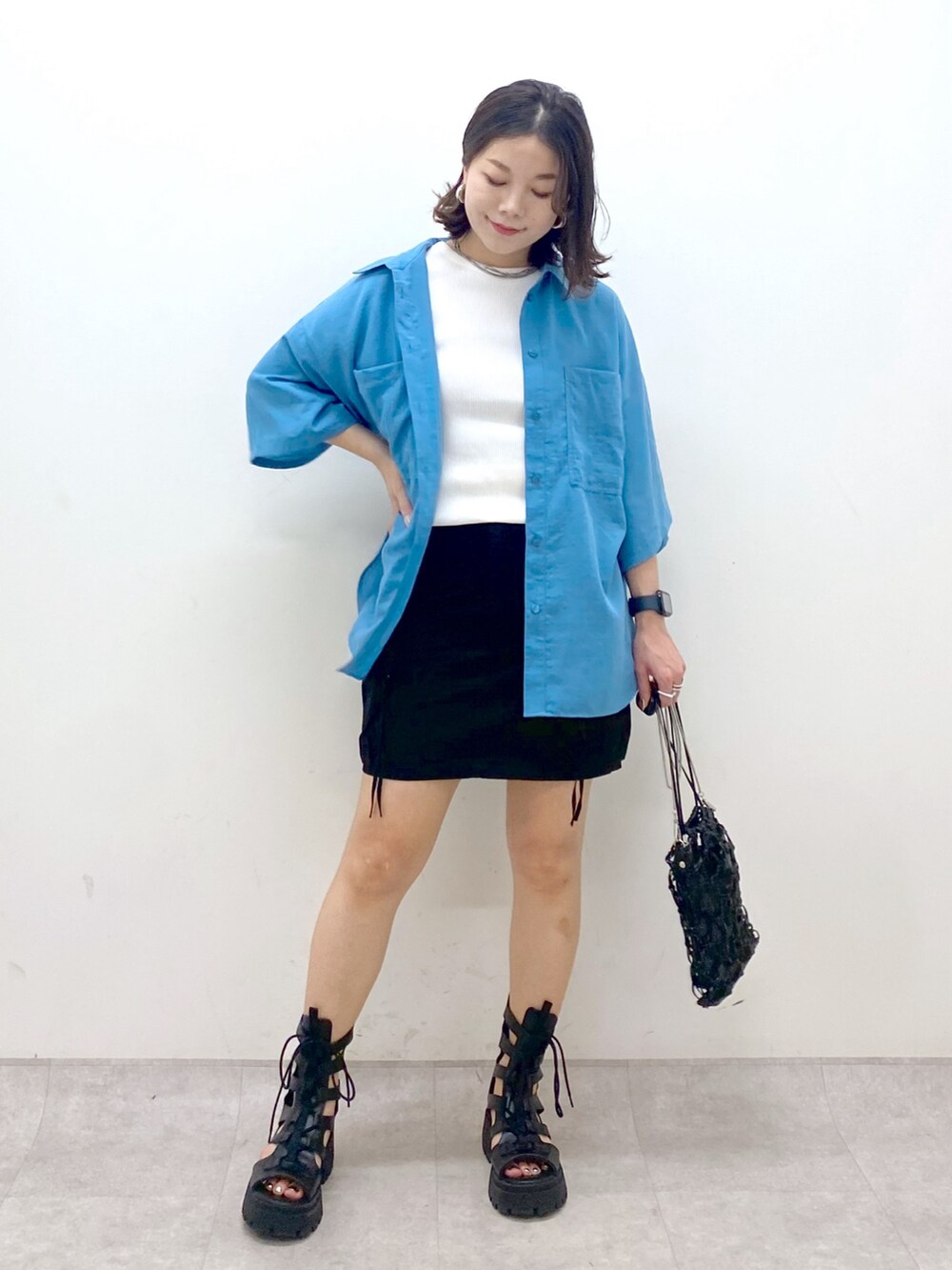 ブルー系のシャツ/ブラウス、ホワイト系のタンクトップ、ブラック系のスカートを着用したレディースの夏コーディネートの4枚目の写真