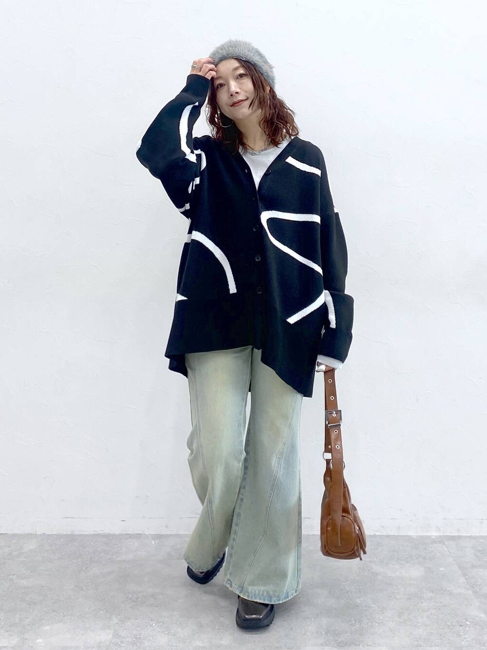 ホワイト系のTシャツ/カットソー、ブルー系のデニムパンツ、ブラック系のカーディガン/ボレロを着用したレディースの秋コーディネートの9枚目の写真