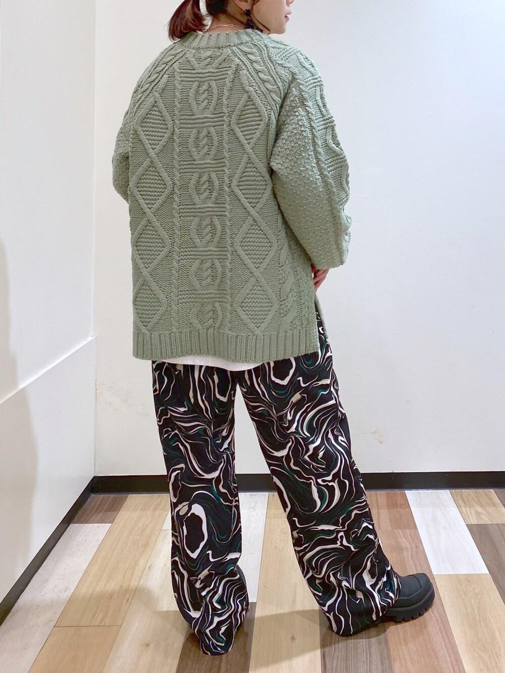 グリーン系のニット/セーター、ブラック系のその他パンツ、ブラック系のブーツを着用したレディースの冬コーディネートの4枚目の写真