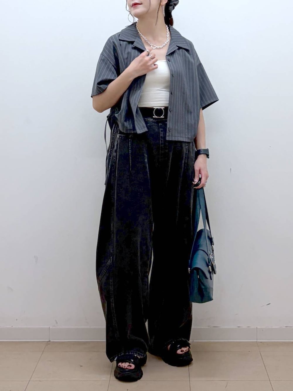 ブラック系のデニムパンツ、ブラック系のサンダル、グレー系のシャツ/ブラウスを着用したレディースの夏コーディネートの3枚目の写真