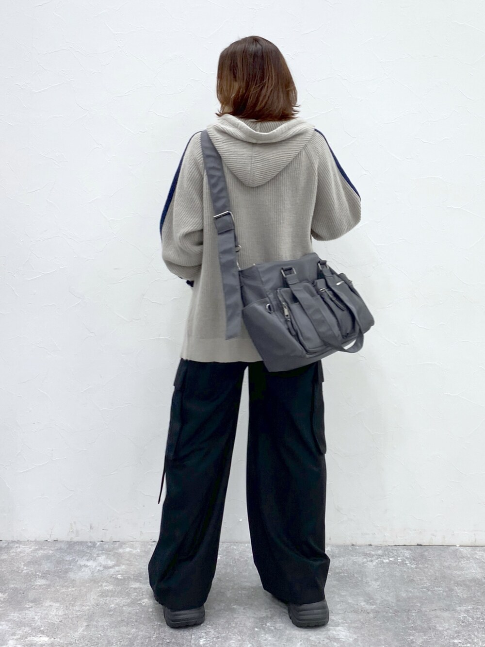グレー系のニット/セーター、ブラック系のTシャツ/カットソー、ブラック系のスラックスを着用したレディースの秋コーディネートの6枚目の写真