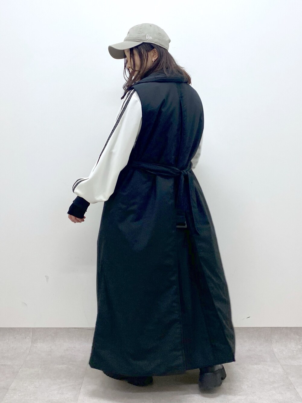 ブラック系のベスト、ブラック系のブーツ、ホワイト系のジャージを着用したレディースの秋コーディネートの6枚目の写真