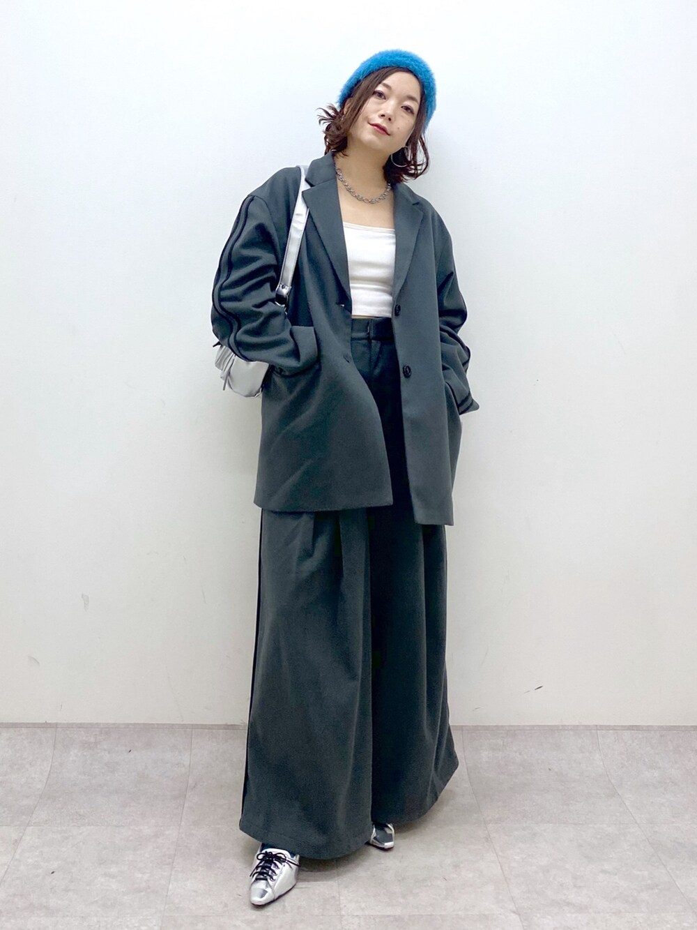 グレー系のスラックス、シルバー系のパンプス、シルバー系のショルダーバッグを着用したレディースの秋コーディネートの9枚目の写真