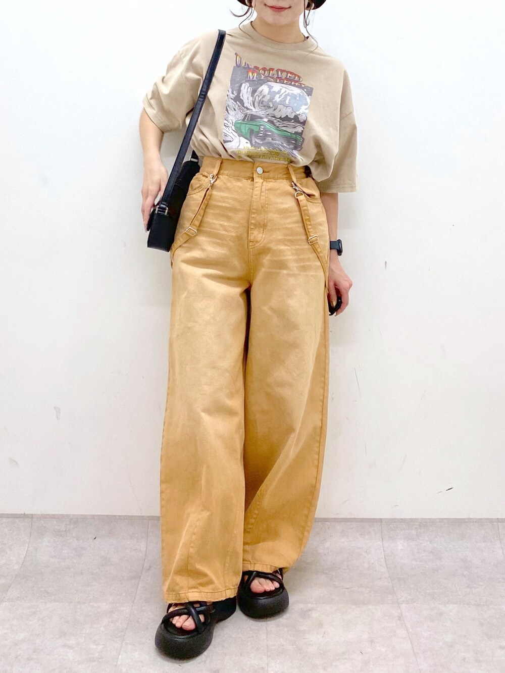 ベージュ系のTシャツ/カットソー、ベージュ系のデニムパンツ、ブラック系のサンダルを着用したレディースの春コーディネートの3枚目の写真