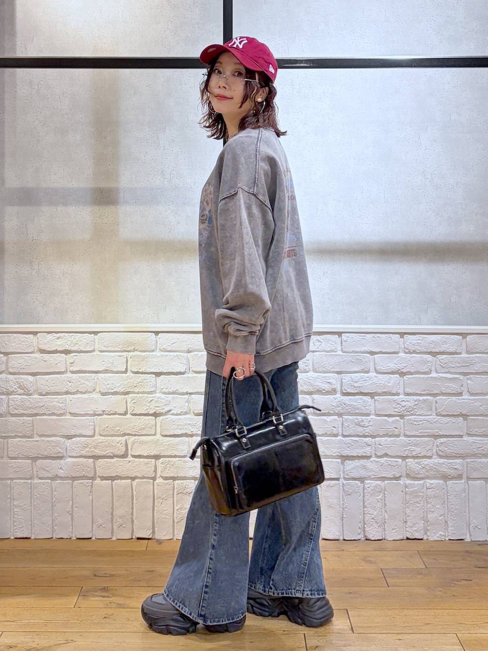 グレー系のスニーカー、ブルー系のデニムパンツ、ブラック系のショルダーバッグを着用したレディースの冬コーディネートの5枚目の写真