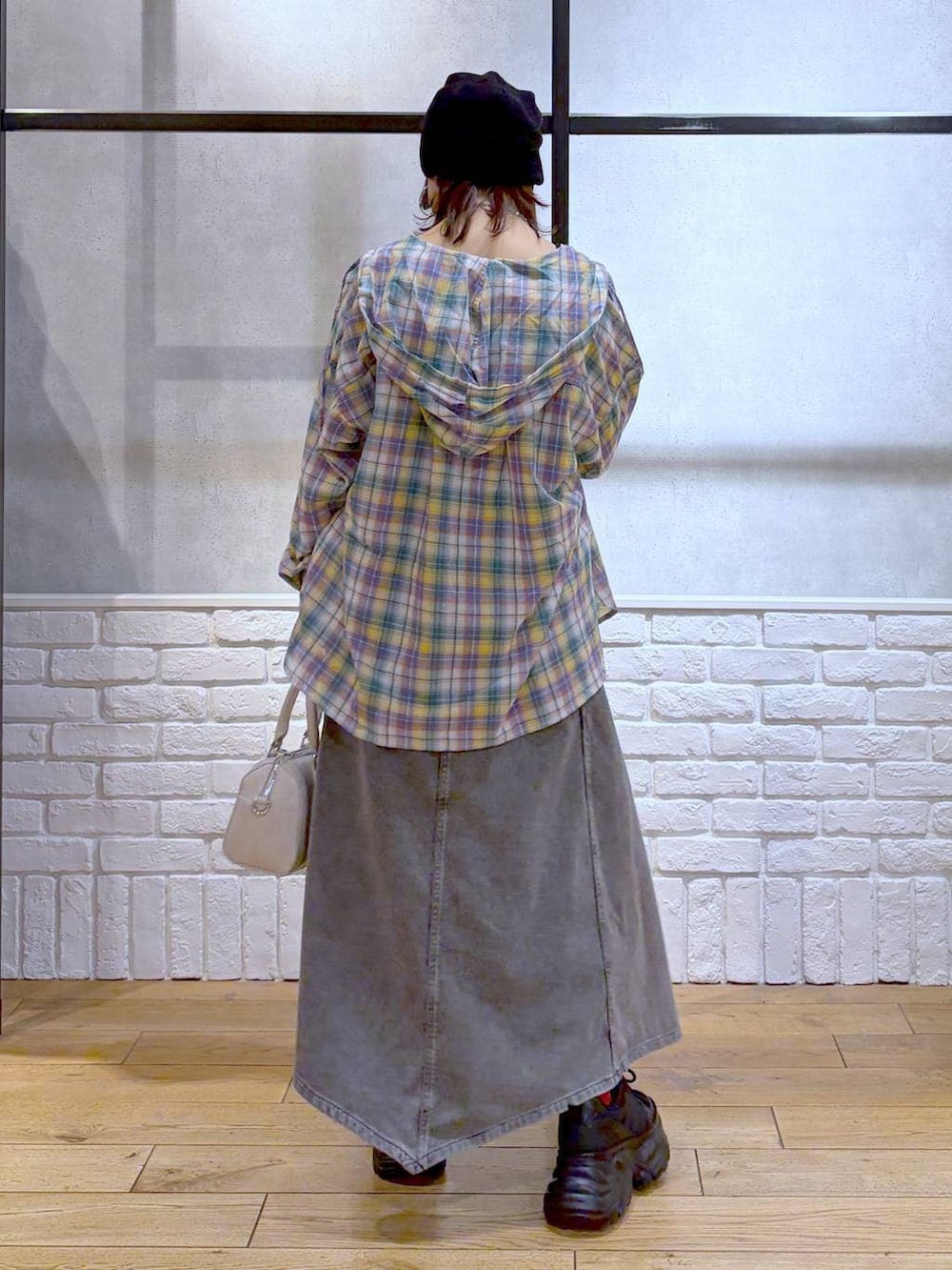 ブラック系のスニーカー、ホワイト系のボストンバッグ、ブラック系のワンピースを着用したレディースの春コーディネートの6枚目の写真