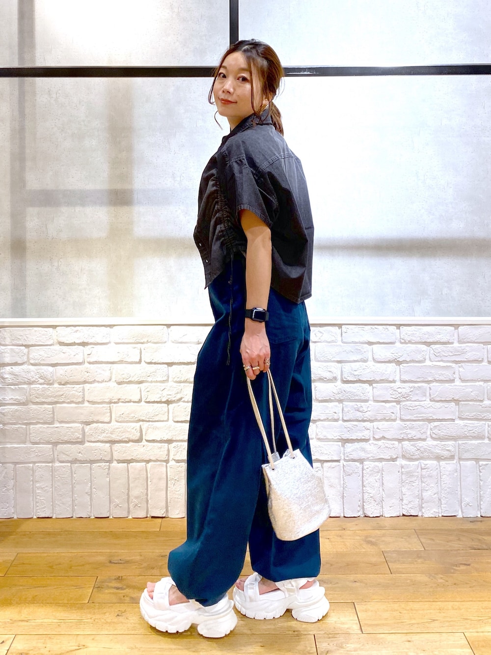 ホワイト系のタンクトップ、ブルー系のチノパンツ、ホワイト系のサンダルを着用したレディースの春コーディネートの7枚目の写真