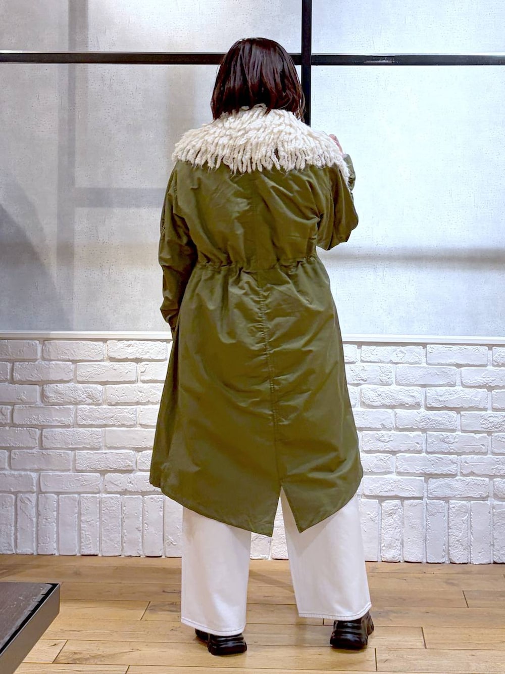 ベージュ系のボストンバッグ、グリーン系のモッズコート、ブラック系のローファーを着用したレディースの冬コーディネートの6枚目の写真