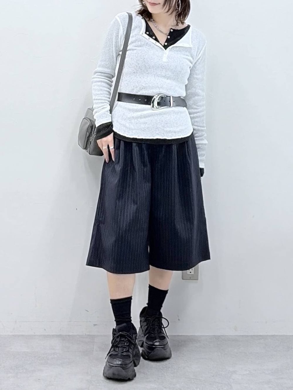 ブラック系のスニーカー、グレー系のショルダーバッグ、ブラック系のTシャツ/カットソーを着用したレディースの春コーディネートの3枚目の写真