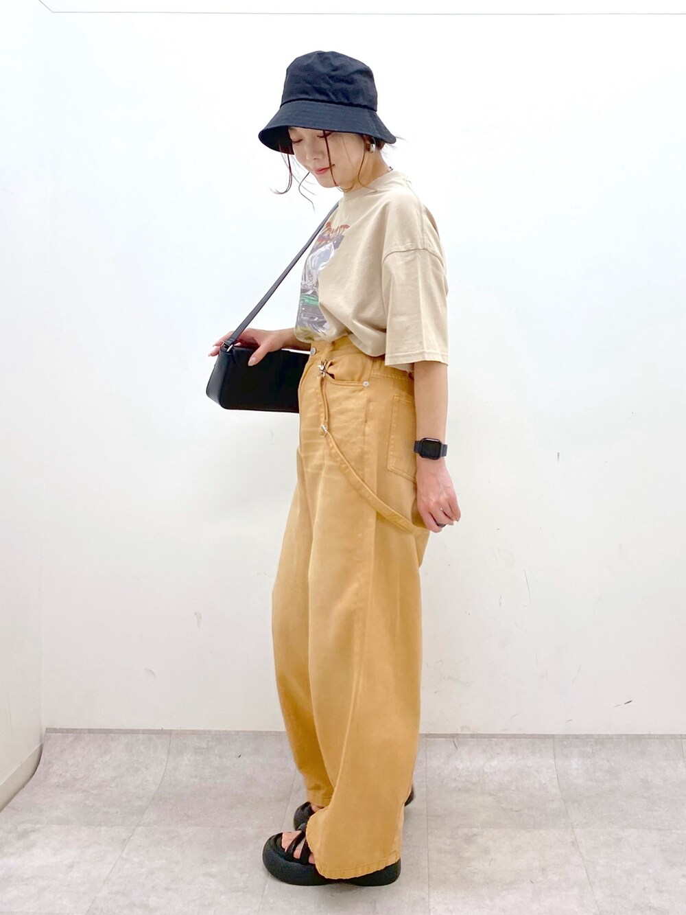 ベージュ系のTシャツ/カットソー、ベージュ系のデニムパンツ、ブラック系のサンダルを着用したレディースの春コーディネートの5枚目の写真