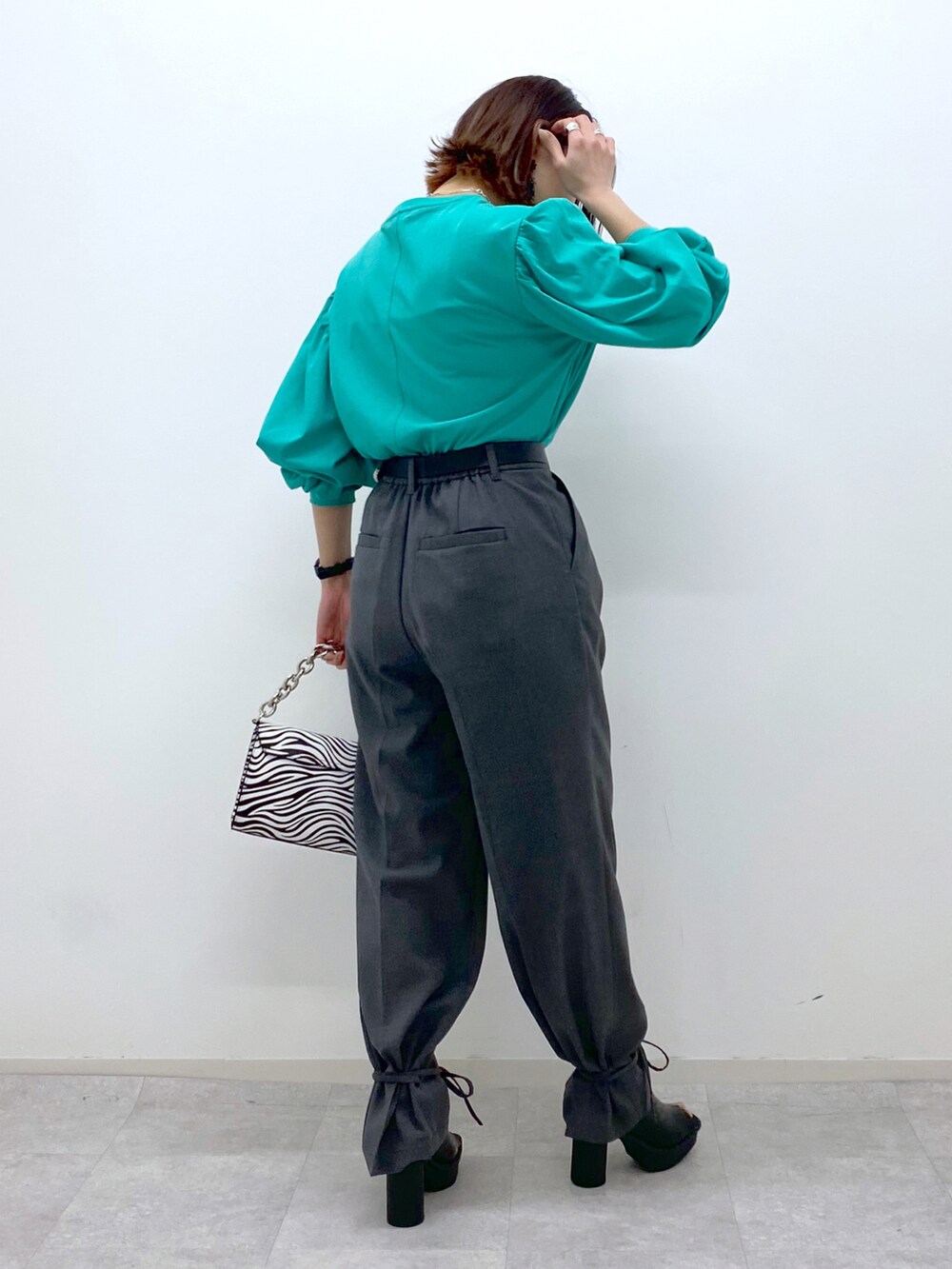 グリーン系のTシャツ/カットソー、グレー系のその他パンツ、その他のショルダーバッグを着用したレディースの春コーディネートの4枚目の写真