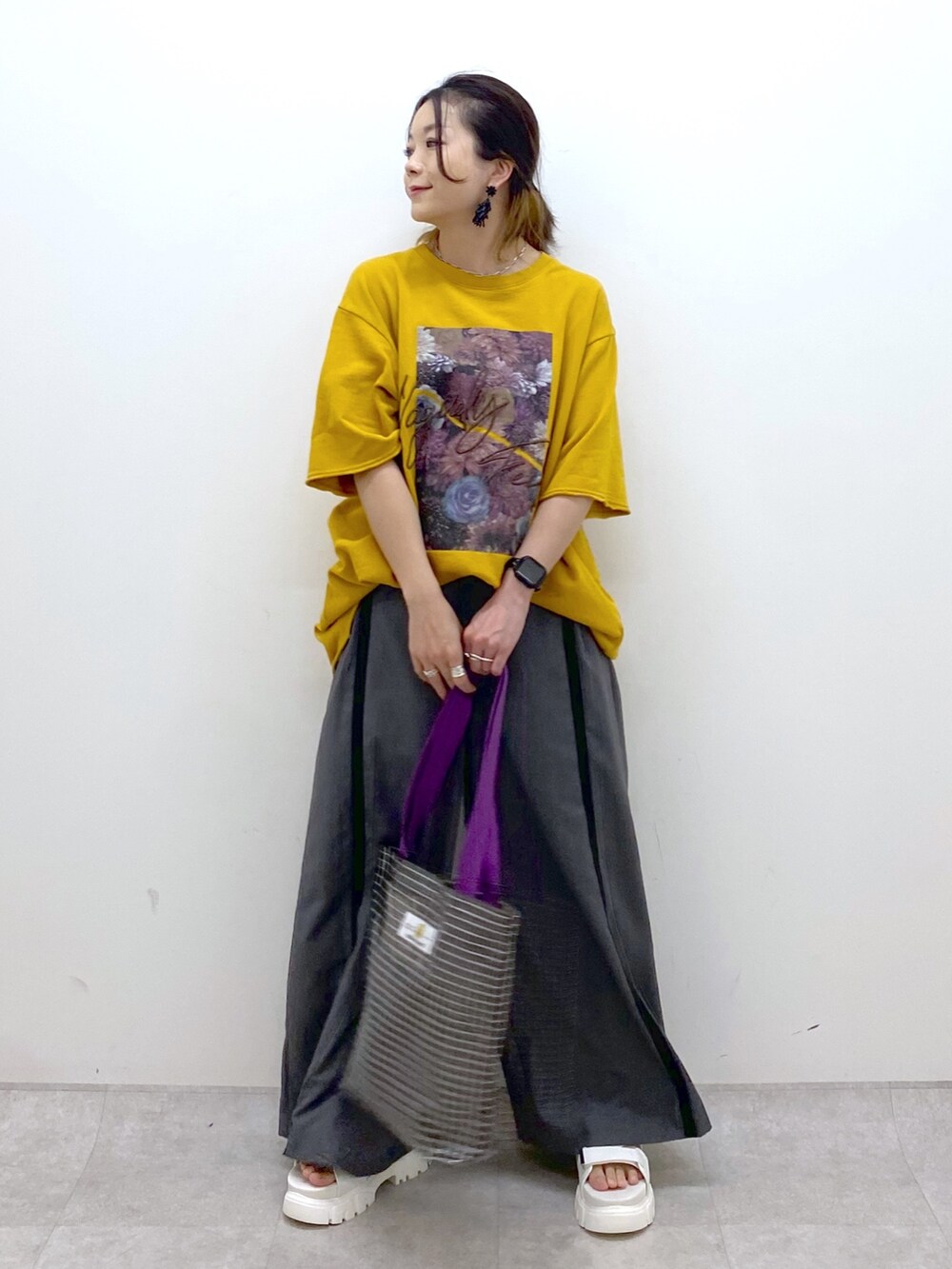 イエロー系のTシャツ/カットソー、グレー系のスラックス、グレー系のトートバッグを着用したレディースの夏コーディネートの2枚目の写真