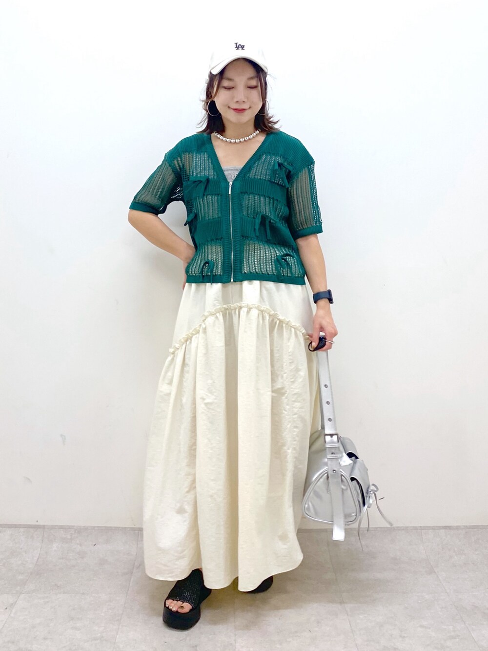 ホワイト系のスカート、グレー系のタンクトップ、シルバー系のショルダーバッグを着用したレディースの夏コーディネートの9枚目の写真