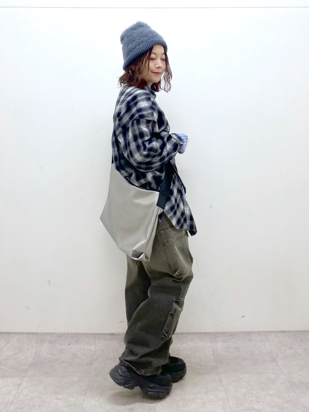 ブラック系のシャツ/ブラウス、シルバー系のトートバッグ、ブルー系のニット/セーターを着用したレディースの冬コーディネートの7枚目の写真