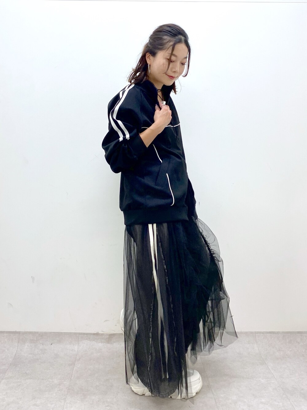 ブラック系のデニムパンツ、ホワイト系のスニーカー、ブラック系のジャージを着用したレディースの夏コーディネートの5枚目の写真
