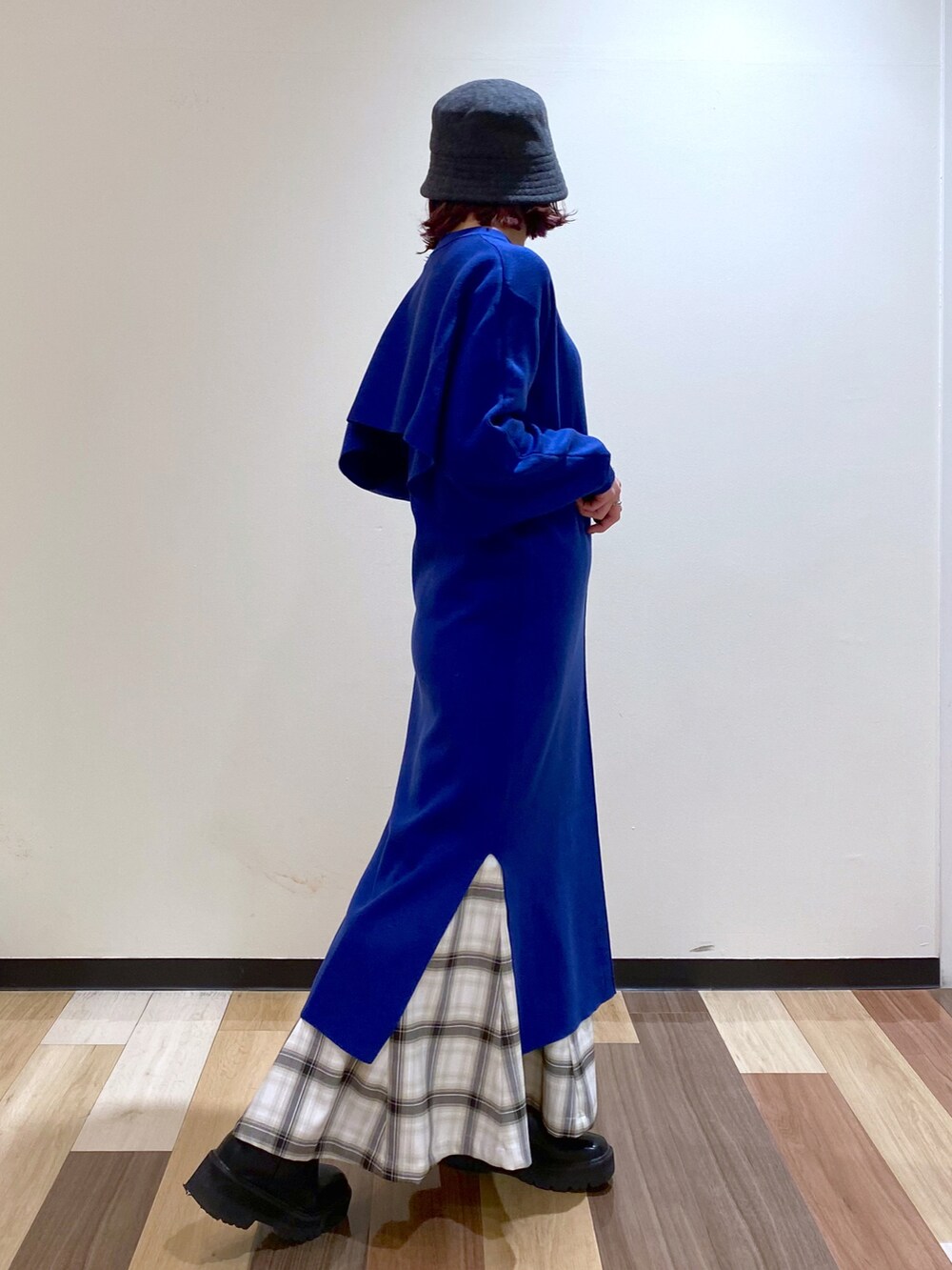 ブルー系のワンピース、ブラック系のブーツ、ホワイト系のスカートを着用したレディースの冬コーディネートの3枚目の写真