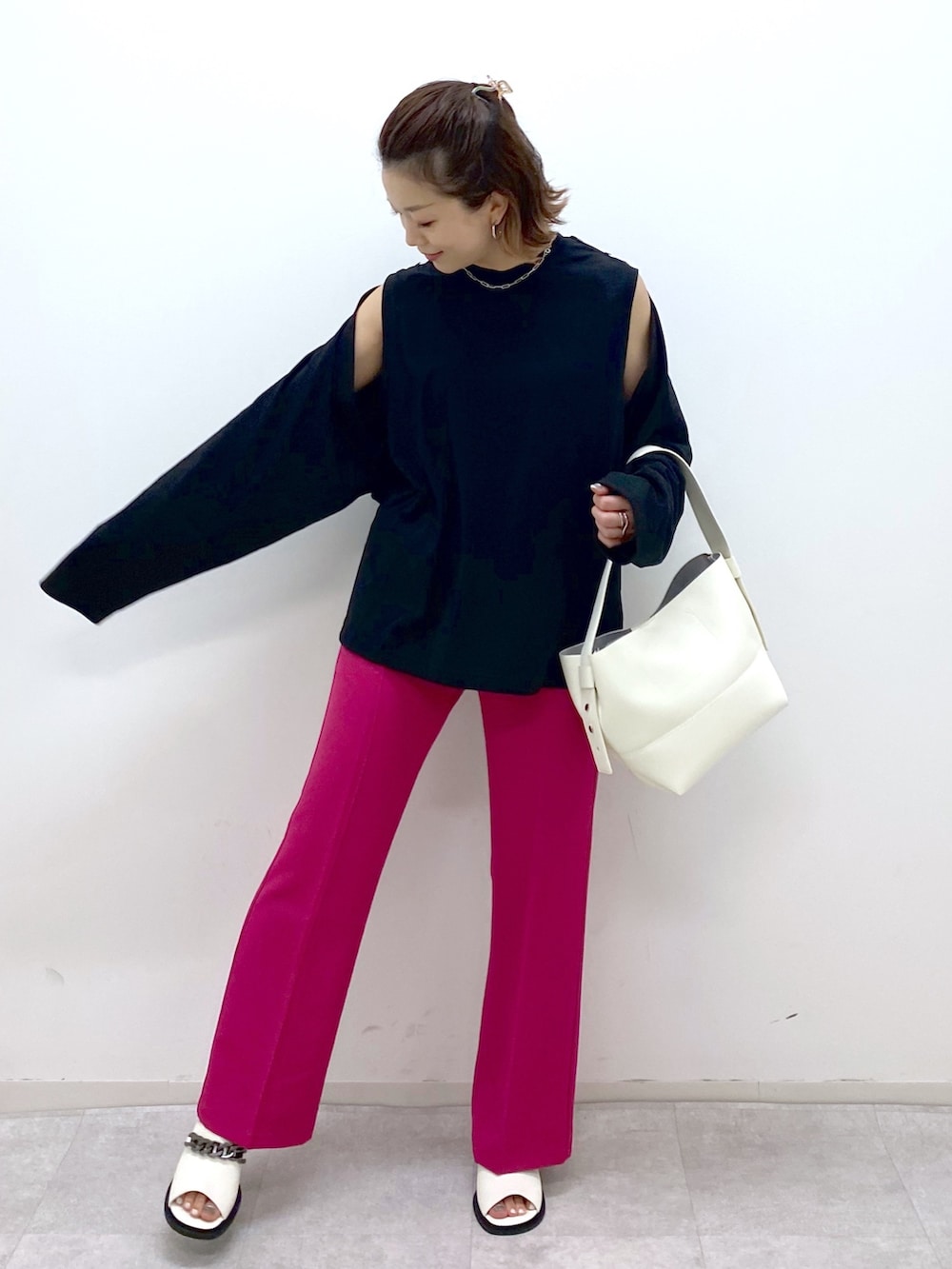 ブラック系のTシャツ/カットソー、ピンク系のスラックス、ホワイト系のバッグを着用したレディースの夏コーディネートの4枚目の写真