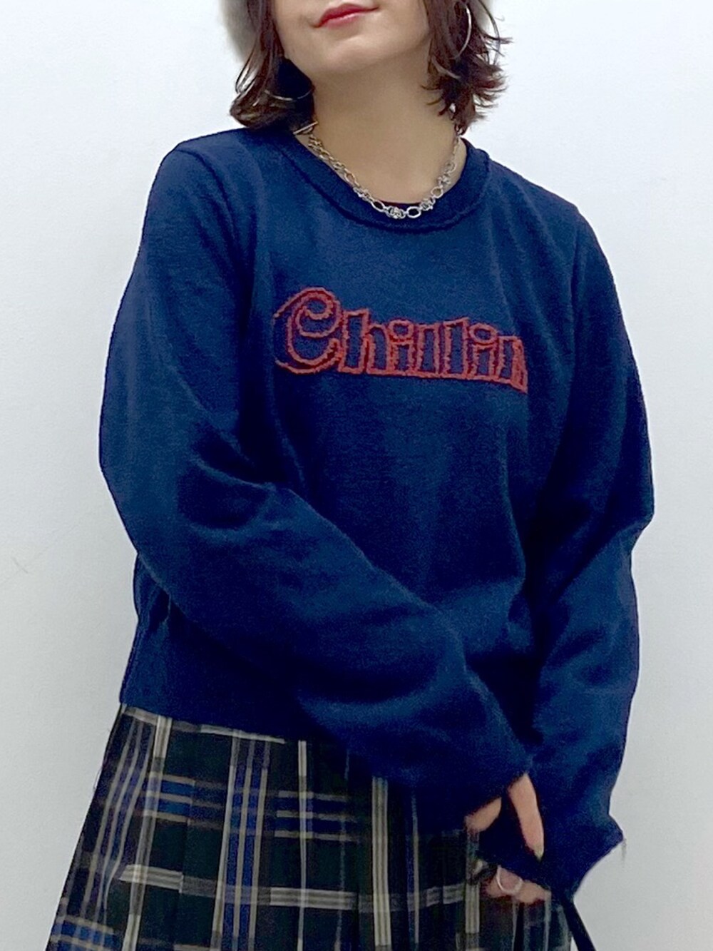 ブルー系のニット/セーター、ブルー系のスカート、ブラック系のショルダーバッグを着用したレディースの秋コーディネートの2枚目の写真