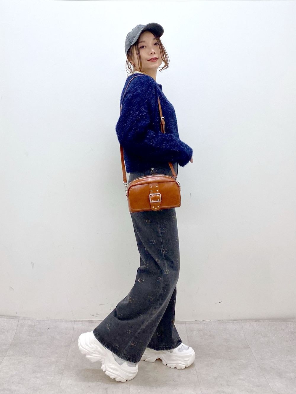 ブルー系のカーディガン/ボレロ、ブラック系のデニムパンツ、ホワイト系のスニーカーを着用したレディースの冬コーディネートの5枚目の写真