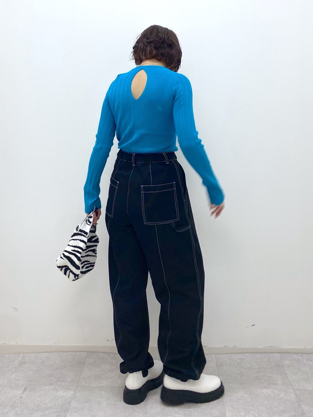 ブラック系のパンツ、ブラック系のバッグ、ホワイト系のシューズを着用したレディースの秋コーディネートの3枚目の写真