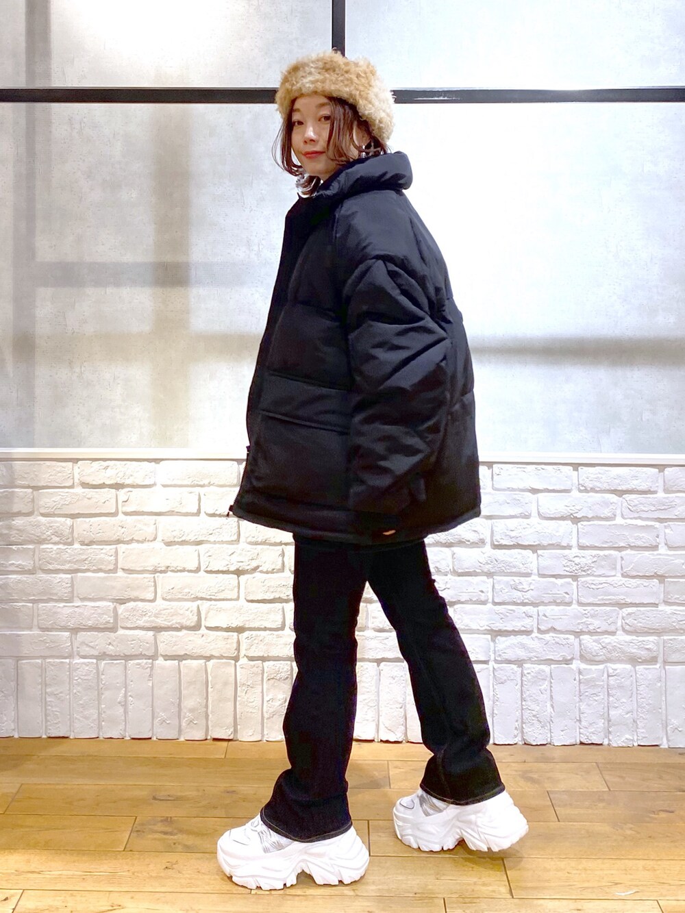 ブルー系のニット/セーター、ブラック系のブルゾン、ブルー系のデニムパンツを着用したレディースの冬コーディネートの7枚目の写真