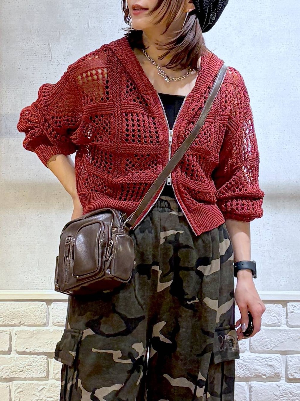 ブラック系のスニーカー、ブラック系のタンクトップ、グリーン系のスウェットパンツを着用したレディースの春コーディネートの2枚目の写真