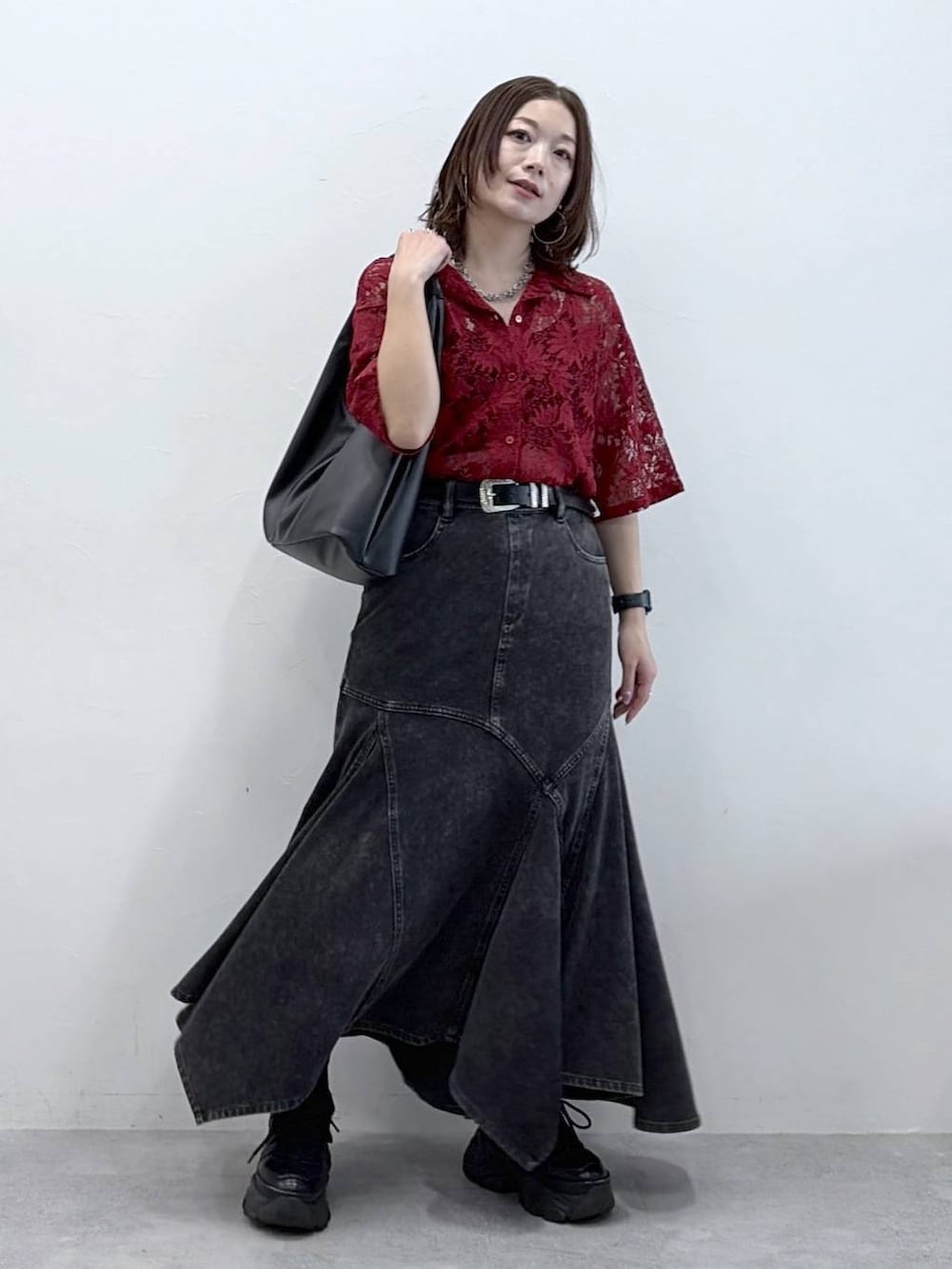 ブラック系のスニーカー、レッド系のシャツ/ブラウス、ブラック系のデニムスカートを着用したレディースの春コーディネートの7枚目の写真