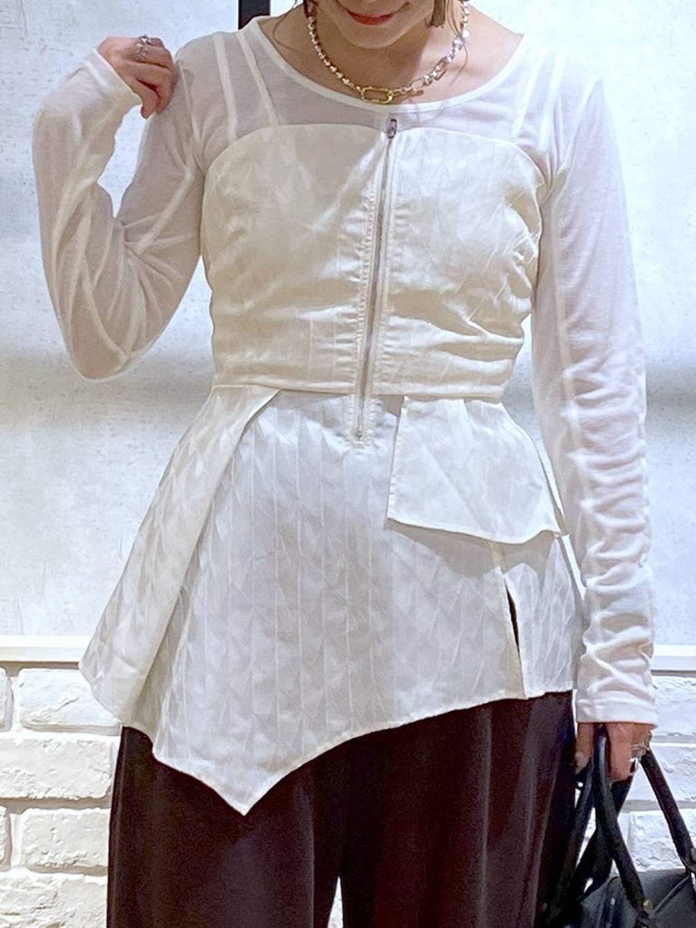 ブラック系のスニーカー、ブラック系のショルダーバッグ、ブラウン系のスウェットパンツを着用したレディースの秋コーディネートの2枚目の写真