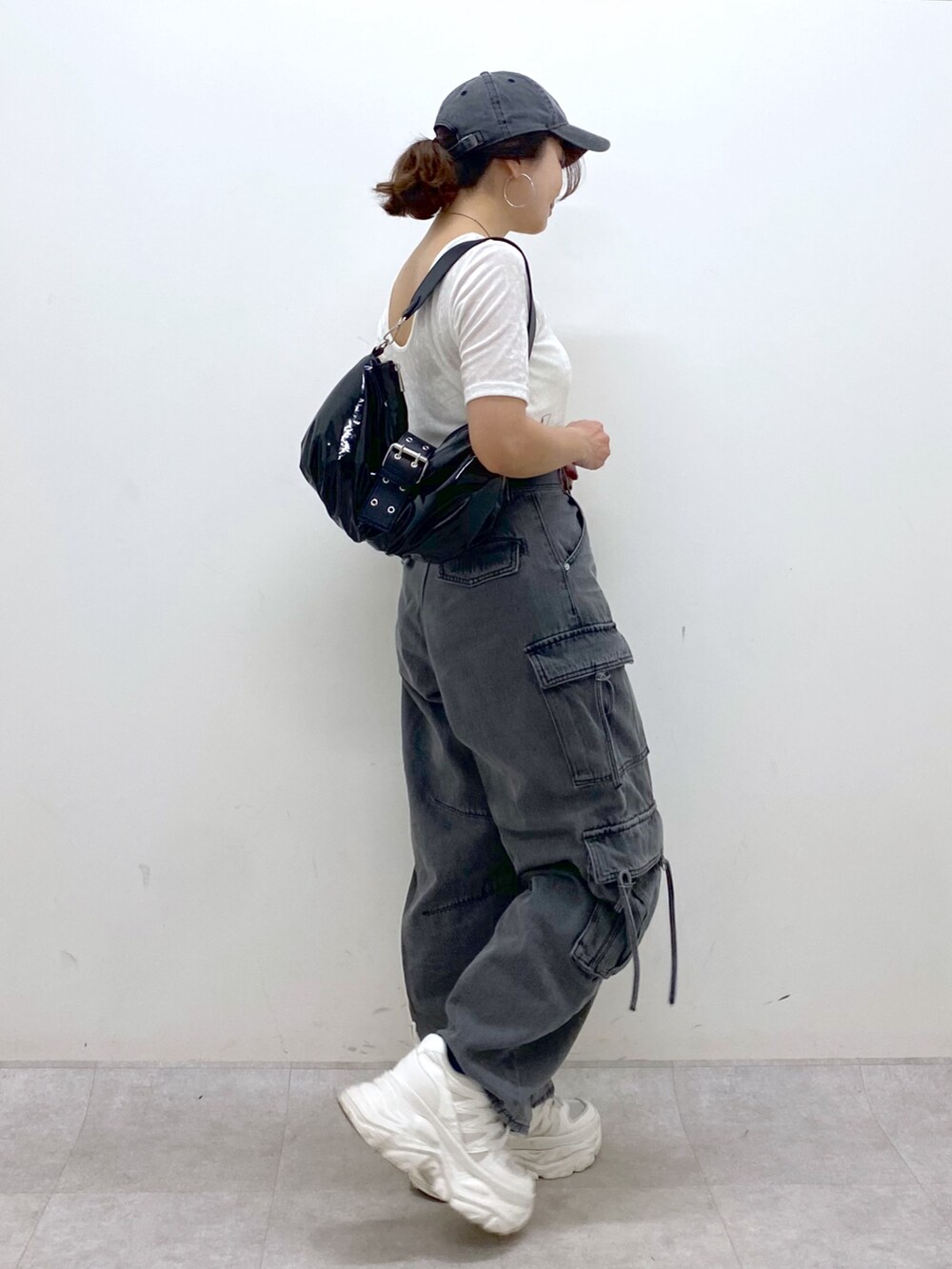 ブラック系のデニムパンツ、ホワイト系のスニーカー、ブラック系のショルダーバッグを着用したレディースの夏コーディネートの6枚目の写真