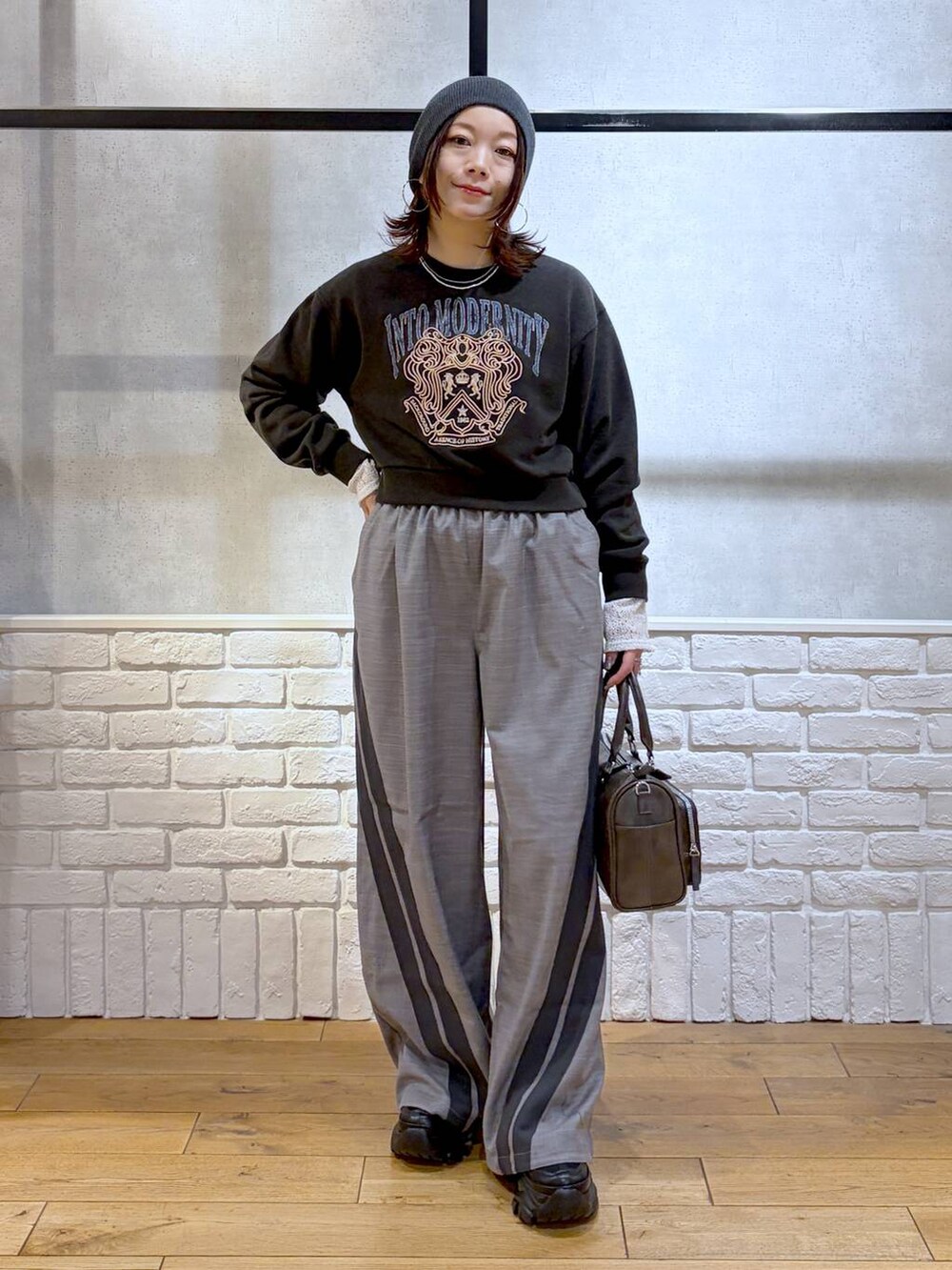 ブラック系のスニーカー、グレー系のスウェット、ブラック系のショルダーバッグを着用したレディースの冬コーディネートの4枚目の写真