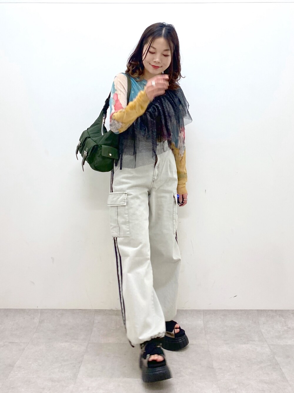 グリーン系のショルダーバッグ、その他のスニーカー、ホワイト系のデニムパンツを着用したレディースの春コーディネートの7枚目の写真