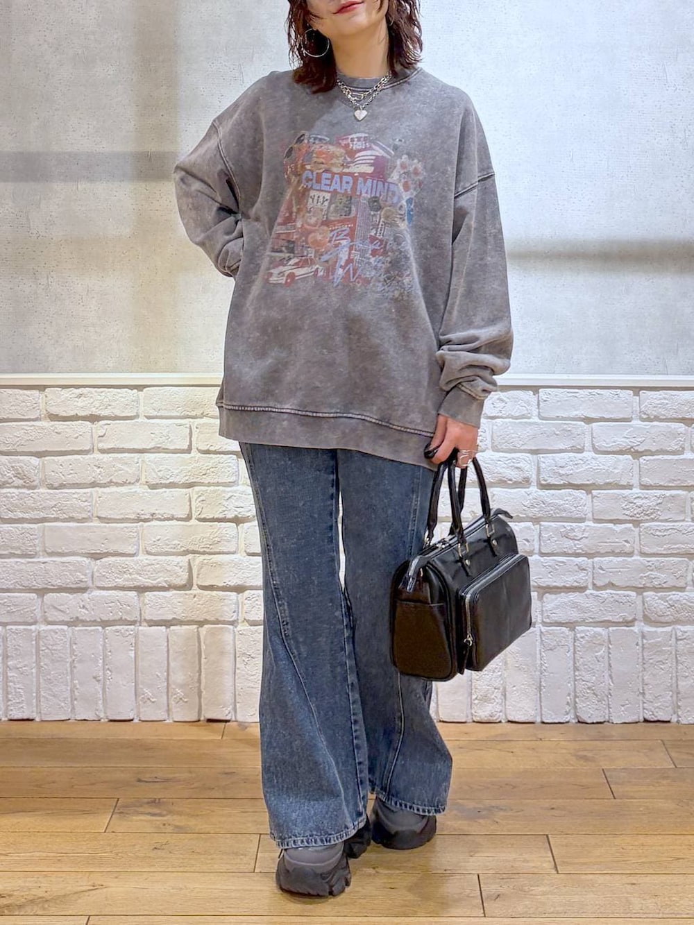 グレー系のスニーカー、ブルー系のデニムパンツ、ブラック系のショルダーバッグを着用したレディースの冬コーディネートの3枚目の写真