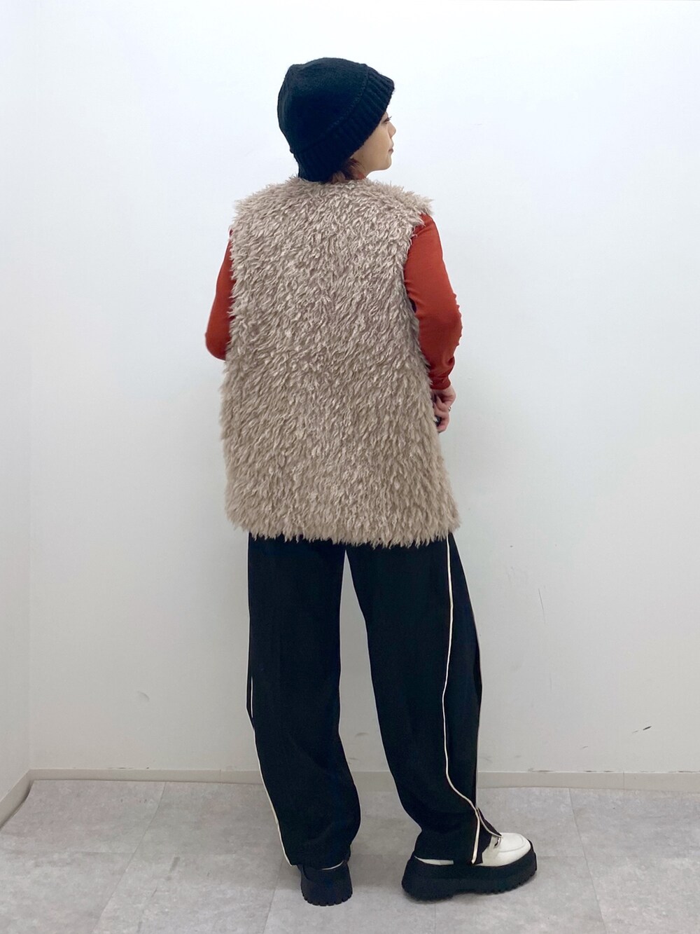 ベージュ系のその他アウター、オレンジ系のTシャツ/カットソー、ホワイト系のシューズを着用したレディースの秋コーディネートの3枚目の写真