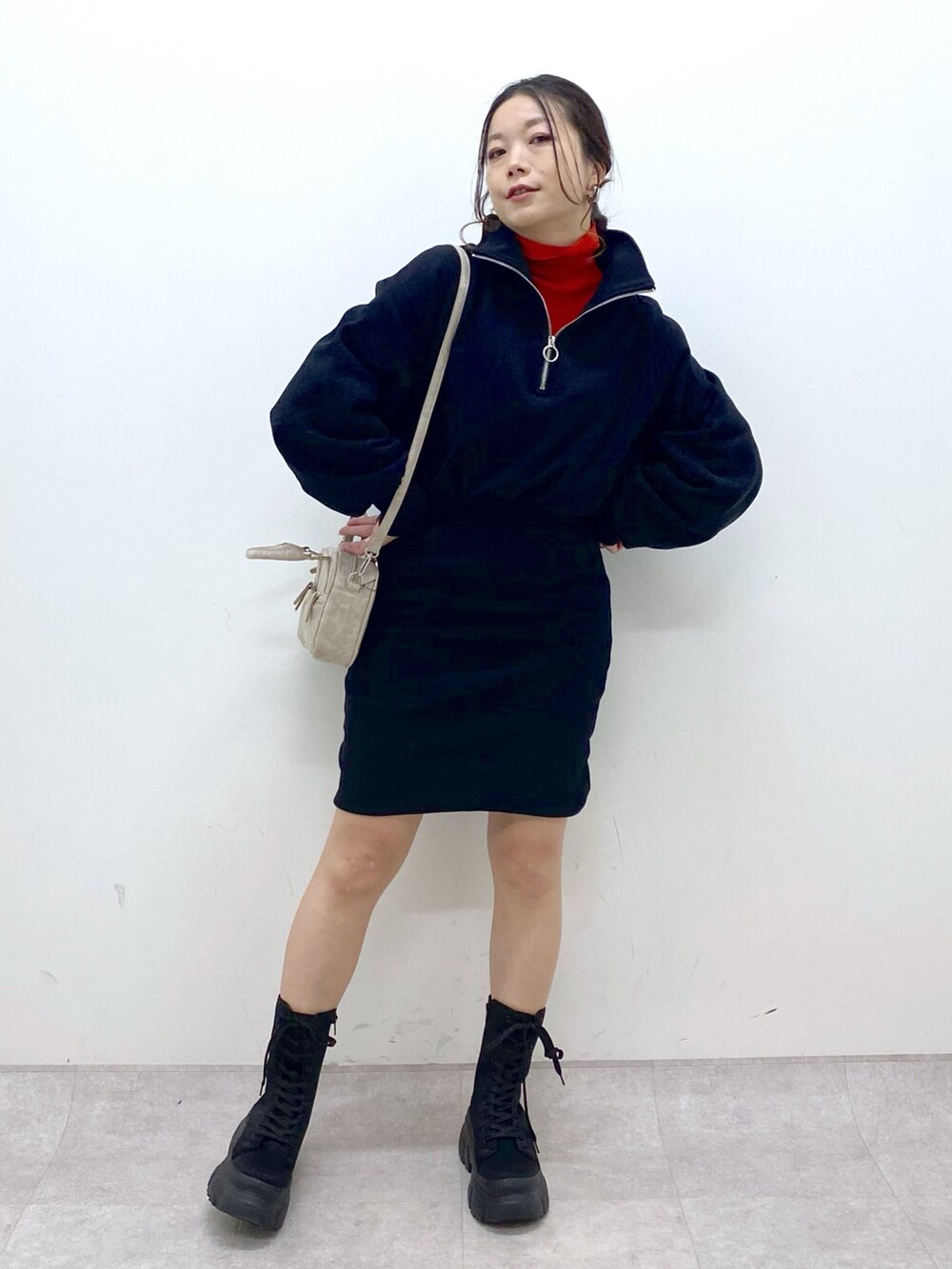 ブラック系のワンピース、レッド系のニット/セーター、ベージュ系のボストンバッグを着用したレディースの冬コーディネートの2枚目の写真