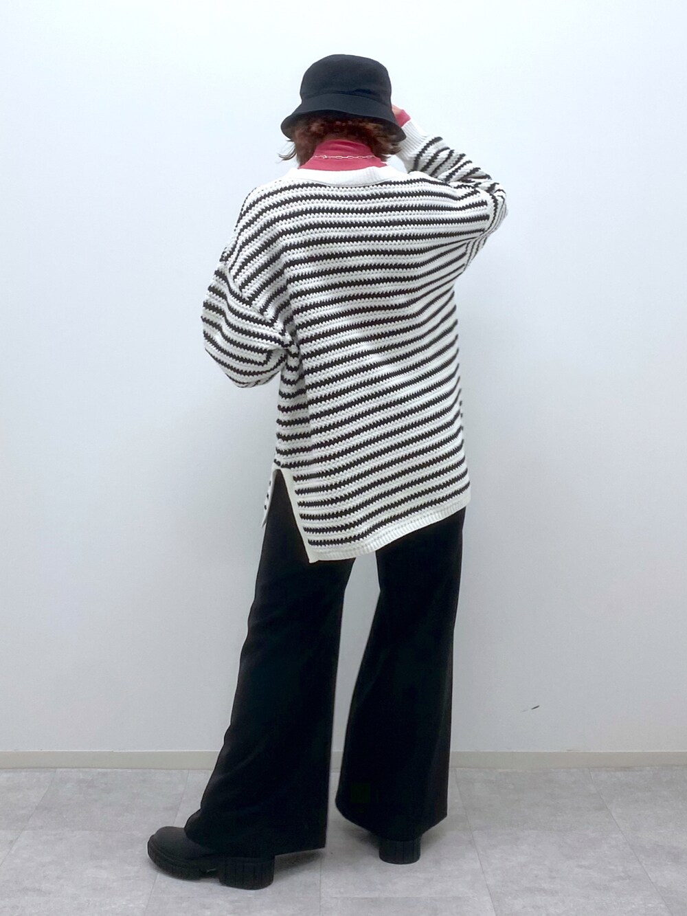 ホワイト系のニット/セーター、ピンク系のTシャツ/カットソー、ブラック系のスラックスを着用したレディースの春コーディネートの4枚目の写真